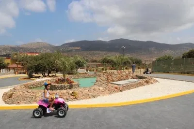 La niña monta un quad en un parque de vacaciones.